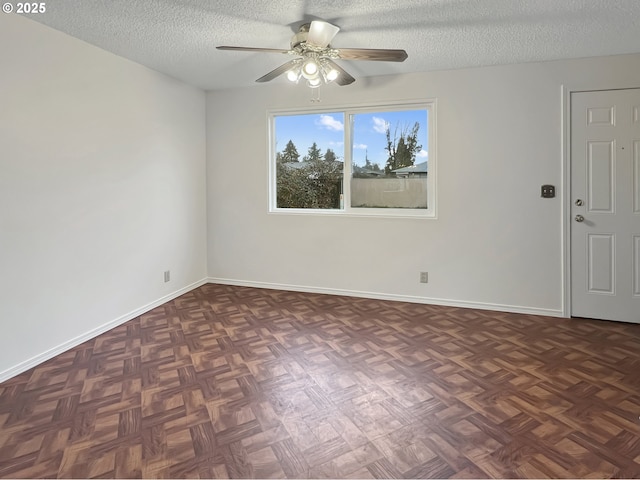 empty room featuring ceiling fan, baseboards, and a textured ceiling