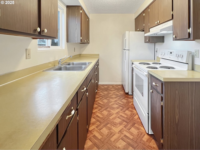 kitchen with under cabinet range hood, light countertops, electric stove, a textured ceiling, and a sink