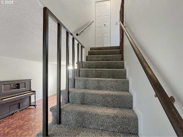 stairs featuring a textured ceiling