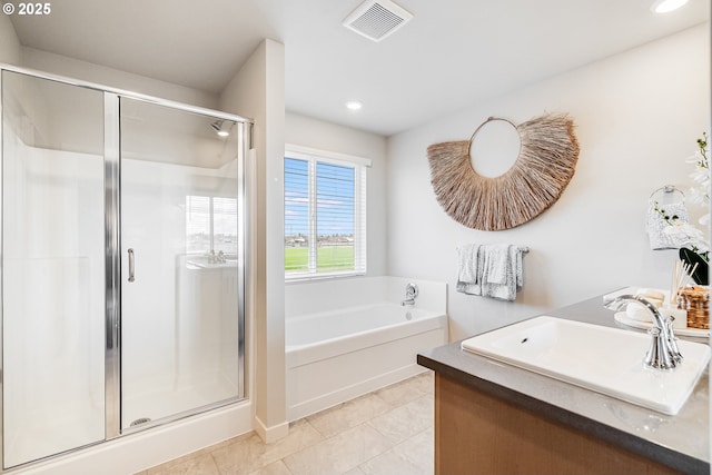 bathroom with plus walk in shower, tile patterned flooring, and vanity