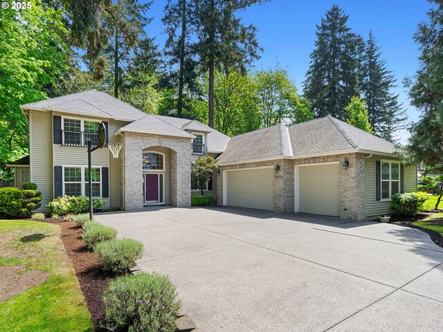 17712 SW 81st Pl, Durham, OR 97224 - view of front facade with an attached garage, driveway, brick siding, and roof with shingles