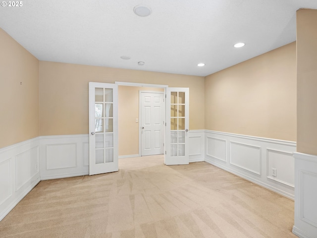 17712 SW 81st Pl, Durham, OR 97224 - empty room featuring french doors, carpet flooring, wainscoting, a decorative wall, and recessed lighting