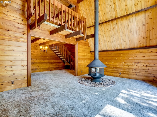 26619 NE 77th Ave, Battle Ground, WA 98604 - unfurnished living room featuring stairway, a wood stove, carpet flooring, and wood walls