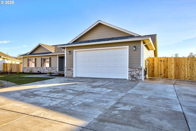 view of front facade with fence, driveway, a front lawn, a garage, and stone siding