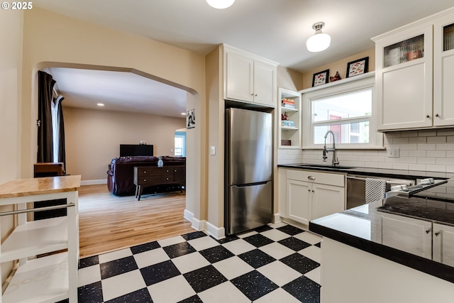 1556 Washington St, Eugene, OR 97401 - kitchen with freestanding refrigerator, a sink, light flooring, dark countertops, and white cabinets