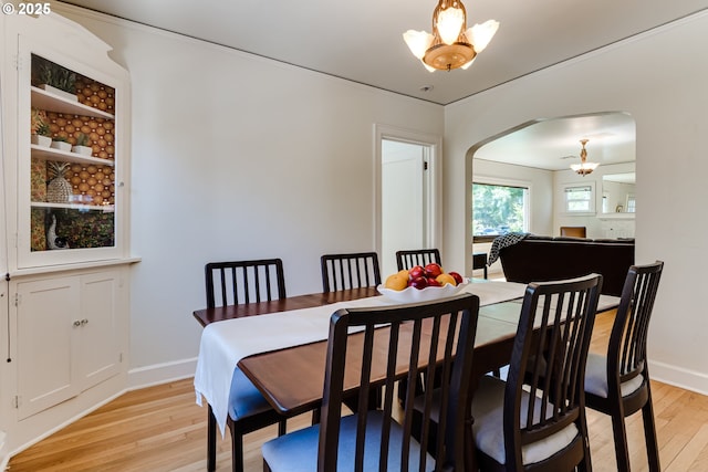 1556 Washington St, Eugene, OR 97401 - dining space featuring arched walkways, light wood finished floors, a chandelier, and baseboards
