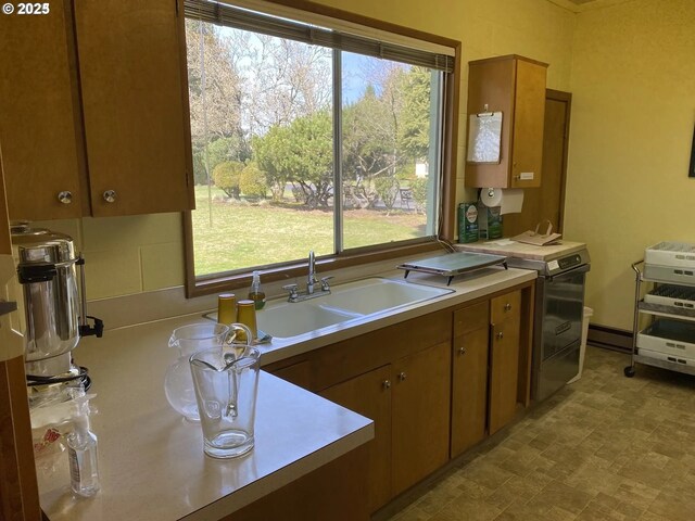 kitchen with range with electric cooktop, backsplash, a baseboard heating unit, and sink