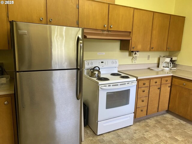 kitchen with white range with electric cooktop and stainless steel refrigerator