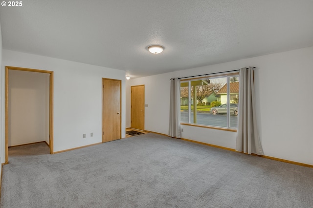 spare room with light colored carpet and a textured ceiling