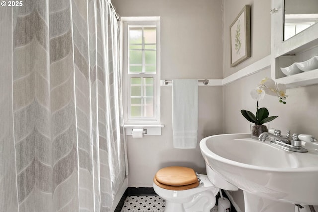 2643 NW Raleigh St Unit 30, Portland, OR 97210 - full bath featuring toilet, a shower with shower curtain, a sink, and baseboards