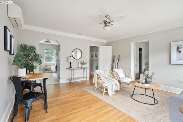 2643 NW Raleigh St Unit 30, Portland, OR 97210 - living area with a wall unit AC, ceiling fan, arched walkways, light wood-style floors, and crown molding