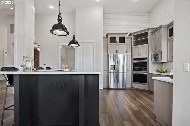 5360 NW 18th Ave, Camas, WA 98607 - kitchen featuring stainless steel appliances, light countertops, dark wood-type flooring, open shelves, and a kitchen breakfast bar