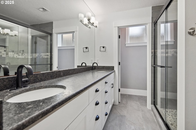 5360 NW 18th Ave, Camas, WA 98607 - bathroom featuring double vanity, a shower stall, a textured ceiling, marble finish floors, and baseboards