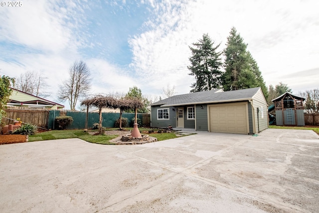 ranch-style house featuring a garage, concrete driveway, and fence