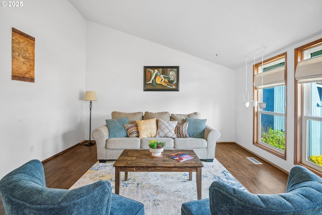 living room featuring lofted ceiling, wood finished floors, visible vents, and baseboards