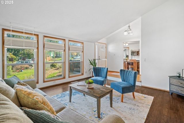 living room with vaulted ceiling, baseboards, and wood finished floors