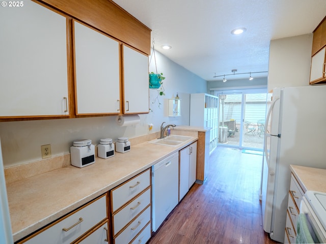 kitchen with light countertops, wood finished floors, white cabinets, white appliances, and a sink