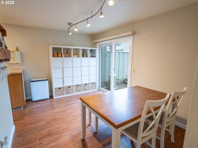 dining space featuring light wood-type flooring and baseboards