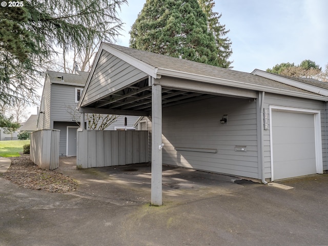 view of parking with a carport, an attached garage, and aphalt driveway