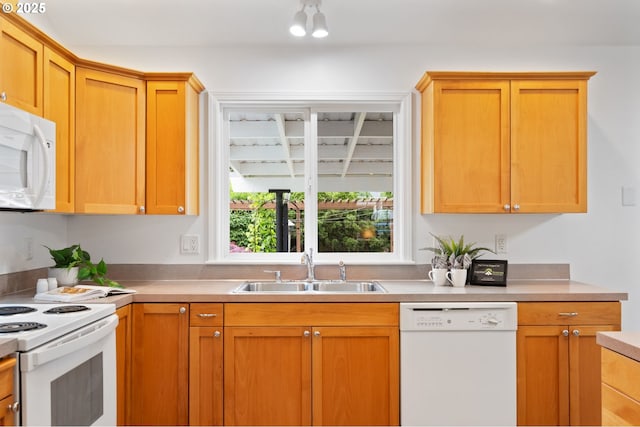 kitchen with white appliances, a sink, and light countertops