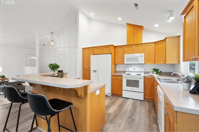 kitchen featuring white appliances, a sink, high vaulted ceiling, light countertops, and a breakfast bar