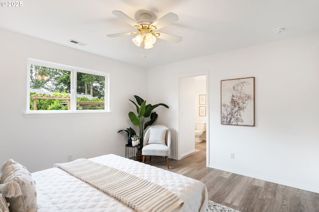 bedroom featuring wood finished floors, baseboards, connected bathroom, and ceiling fan