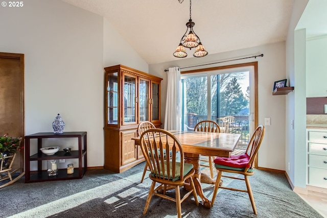 carpeted dining space featuring a notable chandelier and vaulted ceiling