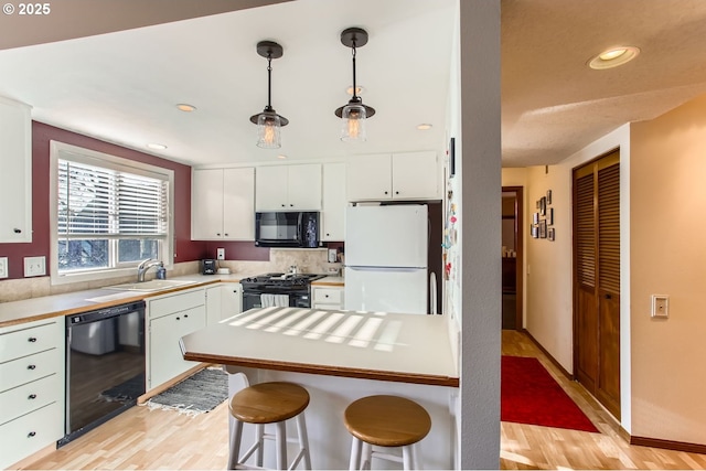 kitchen with decorative backsplash, sink, black appliances, decorative light fixtures, and white cabinets