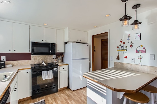 kitchen featuring backsplash, white cabinets, black appliances, and decorative light fixtures