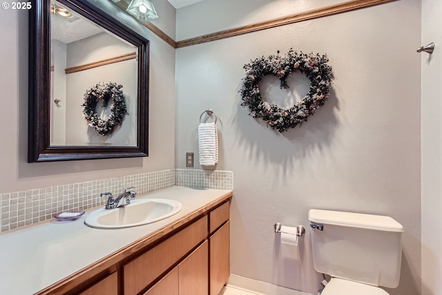 bathroom featuring backsplash, vanity, and toilet