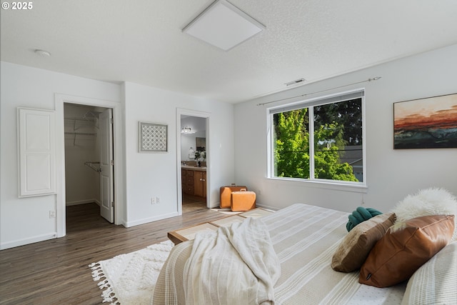 12115 NE 40th Cir, Vancouver, WA 98682 - bedroom featuring wood finished floors, ensuite bathroom, a spacious closet, baseboards, and visible vents