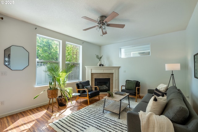 12115 NE 40th Cir, Vancouver, WA 98682 - living area featuring a tiled fireplace, wood finished floors, baseboards, and ceiling fan