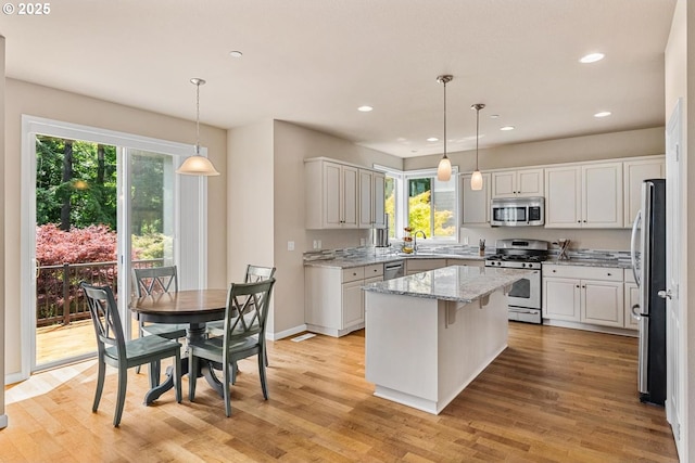 2814 NW Hill St, Camas, WA 98607 - kitchen featuring appliances with stainless steel finishes, a kitchen island, healthy amount of natural light, light wood-style floors, and recessed lighting