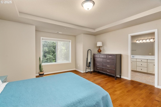 2814 NW Hill St, Camas, WA 98607 - bedroom featuring a raised ceiling, light wood finished floors, and ensuite bath