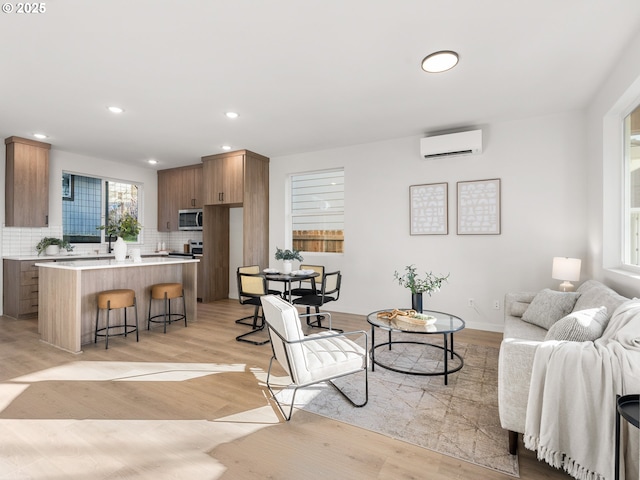 living room with a wall unit AC and light wood-type flooring