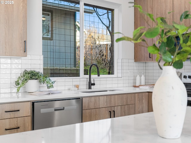 kitchen with backsplash, stainless steel dishwasher, sink, and a wealth of natural light