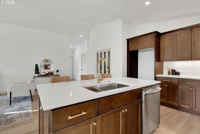 kitchen featuring lofted ceiling, sink, stainless steel dishwasher, and a kitchen island with sink