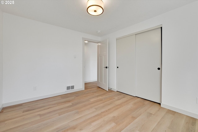 unfurnished bedroom featuring a closet and light wood-type flooring