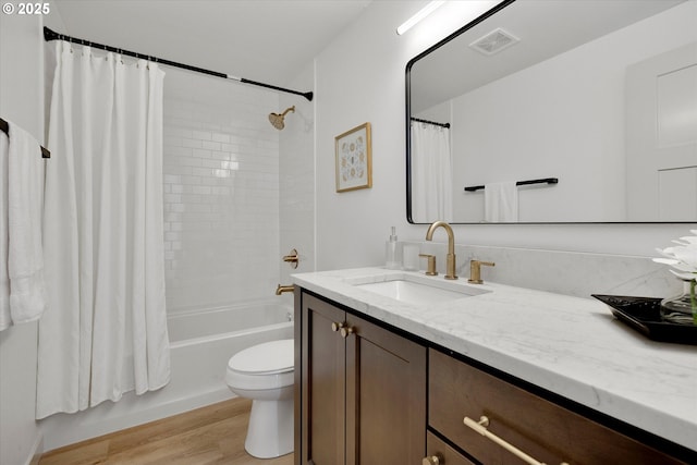 full bathroom featuring shower / bath combo, hardwood / wood-style floors, vanity, and toilet