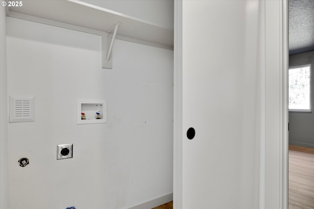 laundry room featuring hookup for a washing machine, hookup for an electric dryer, a textured ceiling, and hardwood / wood-style flooring