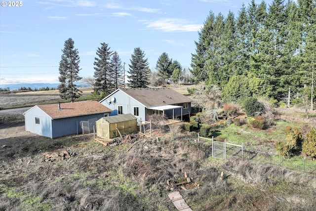 back of property with an outbuilding and a rural view