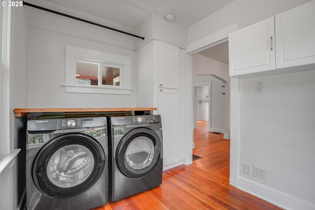 1605 NE 76th Ave, Portland, OR 97213 - laundry room with separate washer and dryer, light wood-style flooring, arched walkways, and cabinet space