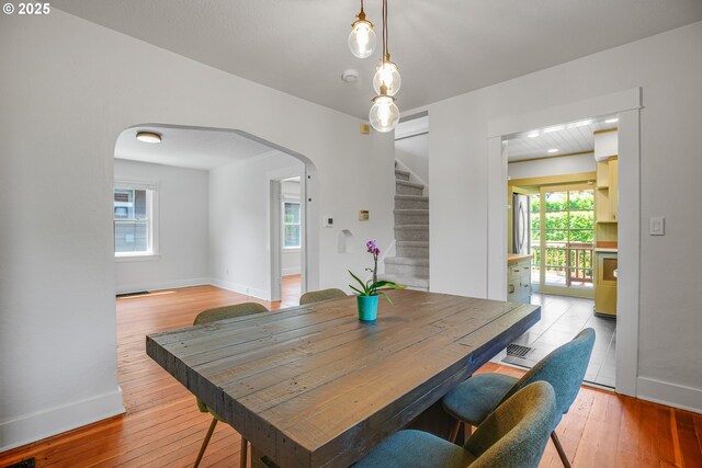 1605 NE 76th Ave, Portland, OR 97213 - dining room with arched walkways, stairway, and light wood-style floors