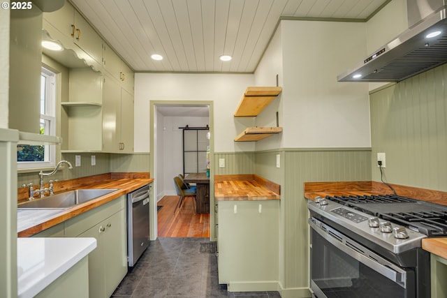 1605 NE 76th Ave, Portland, OR 97213 - kitchen featuring open shelves, appliances with stainless steel finishes, ventilation hood, butcher block countertops, and a wainscoted wall