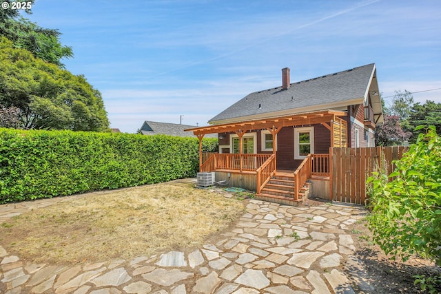 1605 NE 76th Ave, Portland, OR 97213 - back of property featuring a deck, a chimney, a shingled roof, and a patio