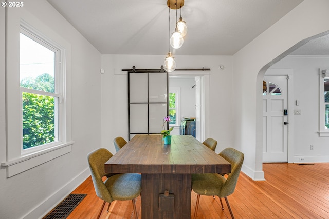 1605 NE 76th Ave, Portland, OR 97213 - dining room with arched walkways, light wood-style floors, and a barn door