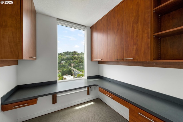 unfurnished office with built in desk and a textured ceiling