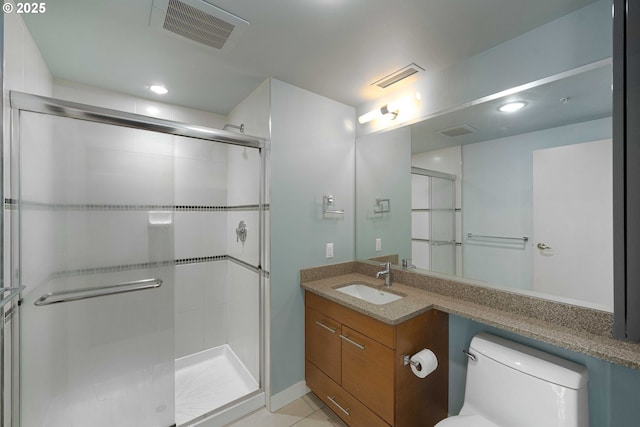 bathroom featuring tile patterned floors, vanity, toilet, and a shower with door