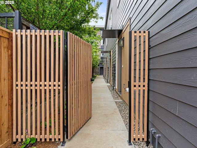 view of side of home with fence and a gate