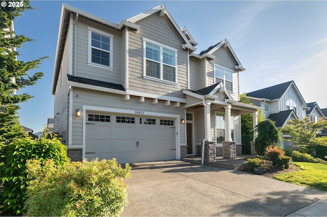 16922 NW Madrone St, Portland, OR 97229 - craftsman-style home featuring an attached garage, concrete driveway, a porch, and stone siding